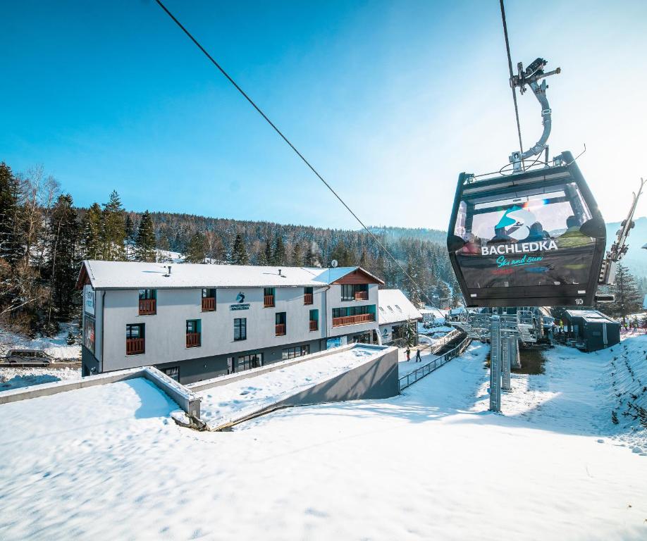 a ski lift with people on it in the snow at Apartmány Bachledka in Ždiar