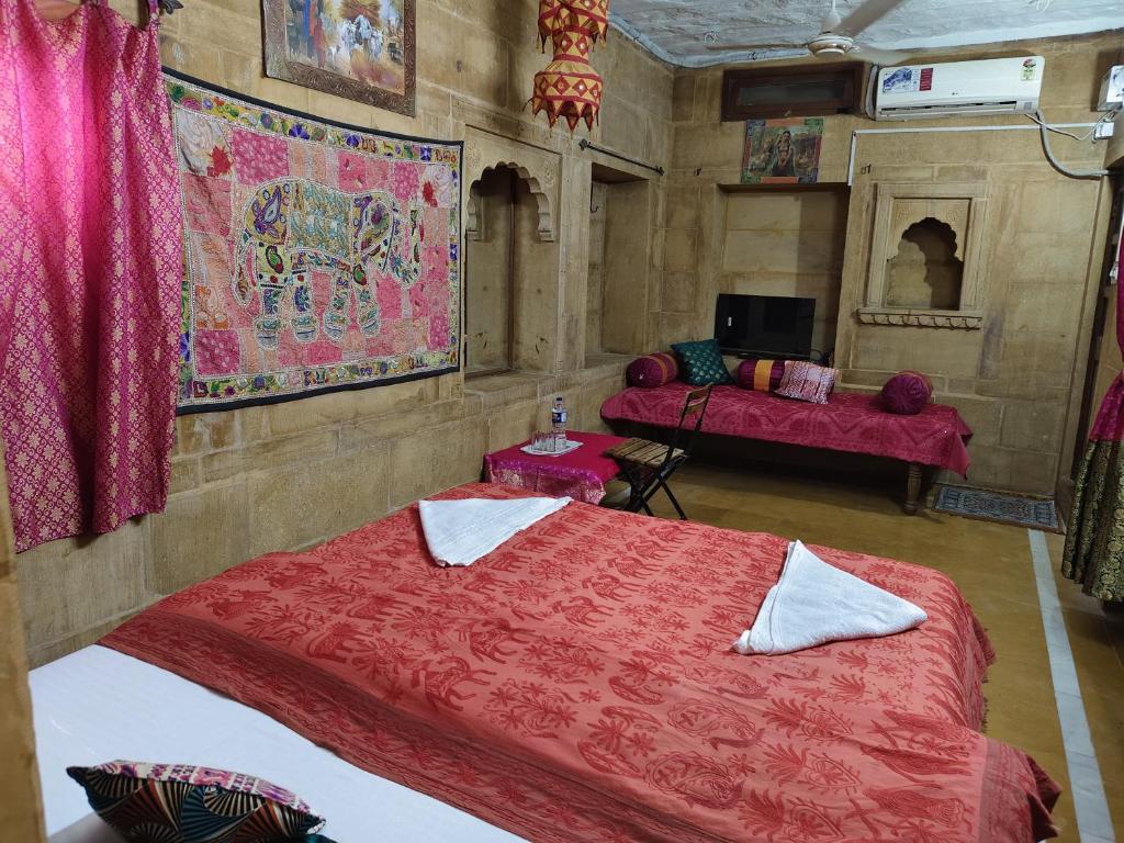 een slaapkamer met twee bedden in een kamer met roze lakens bij hotelchotihaveli in Jaisalmer