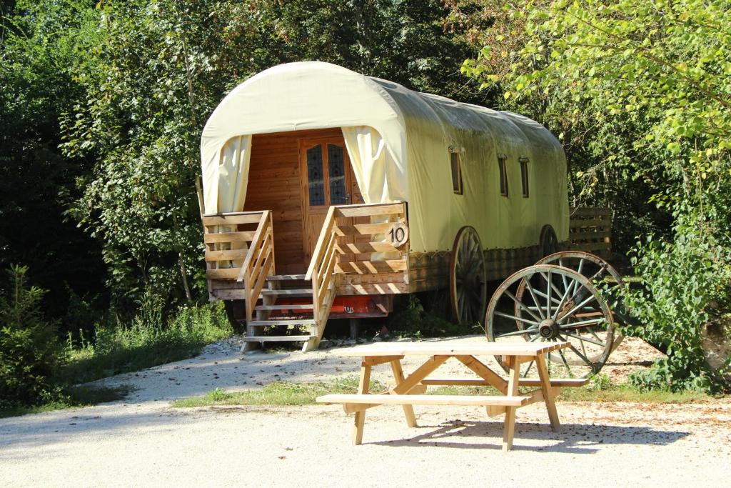 un remolque antiguo con un banco y una casa de madera en Western City Troyes, en Barberey-Saint-Sulpice