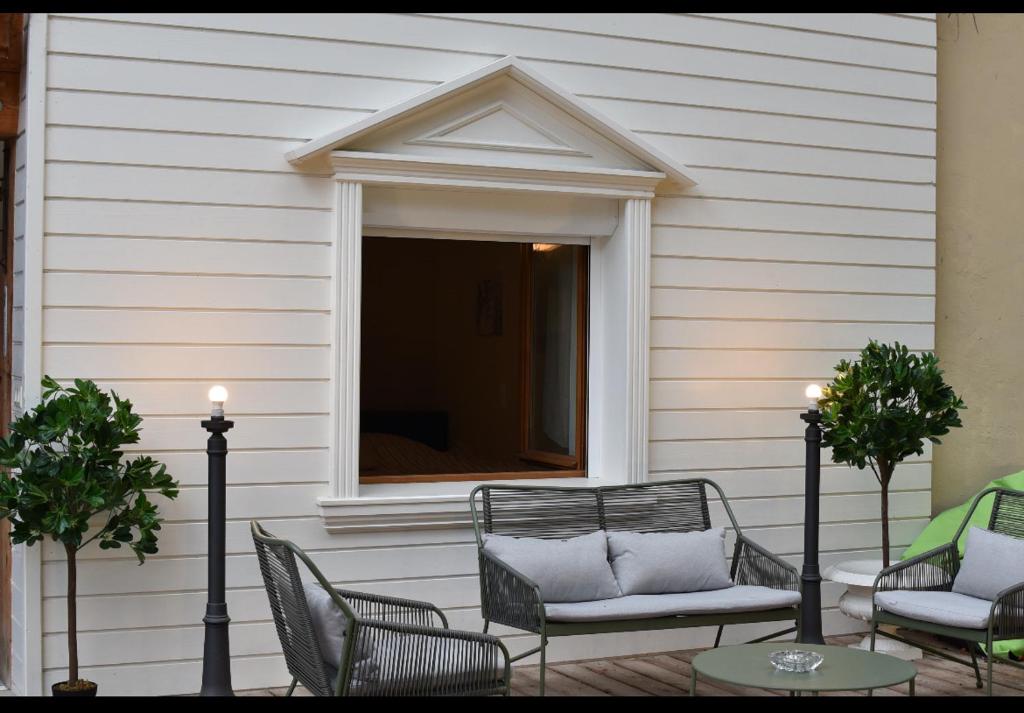 Un patio con sillas y una ventana y una mesa. en cosy studio dans une maison d'hôte, en Bourg-en-Bresse