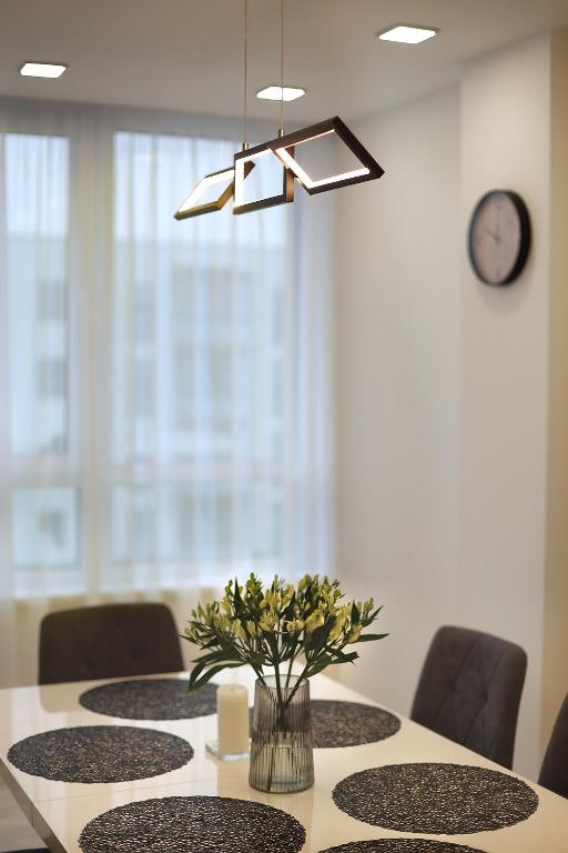a dining room table with a vase of flowers on it at Gargždai, Lithuania in Gargždai