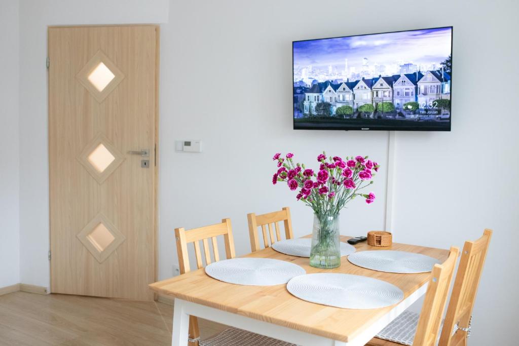 a dining room table with a vase of flowers on it at Domek na Lipowej in Stare Miasto