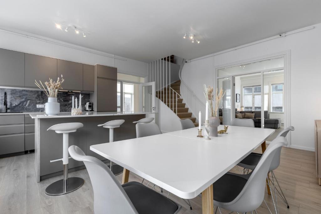 Una cocina y un comedor con una mesa y sillas blancas. en Two story townhouse apartment in old town Reykjavik, en Reikiavik