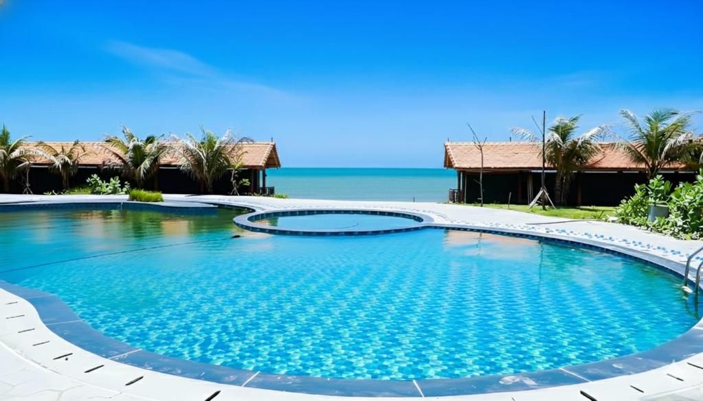 Anna Beach Resort and Restaurant في Ấp Long Sơn: مسبح في المنتجع مع المحيط في الخلفية