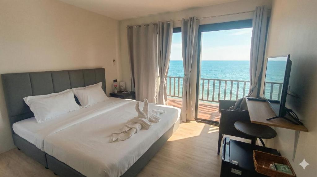 a bedroom with a bed and a view of the ocean at ธัญญ์ รีสอร์ท หินดาด in Ban Pak Nam Chumphon