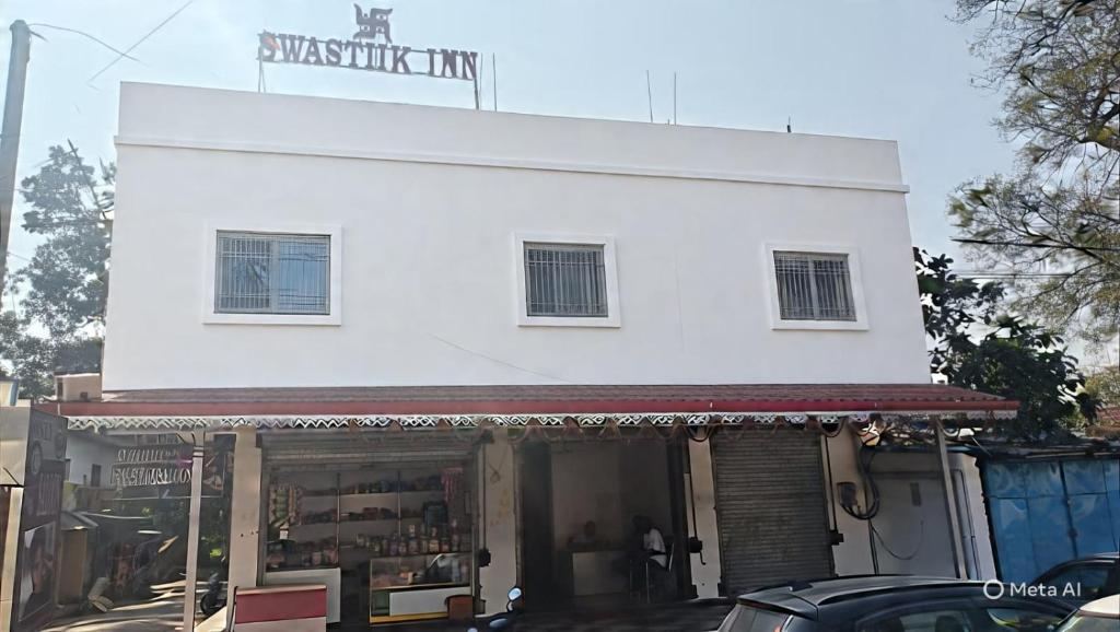 Swastiik Inn的一座白色建筑，顶部有一块招牌