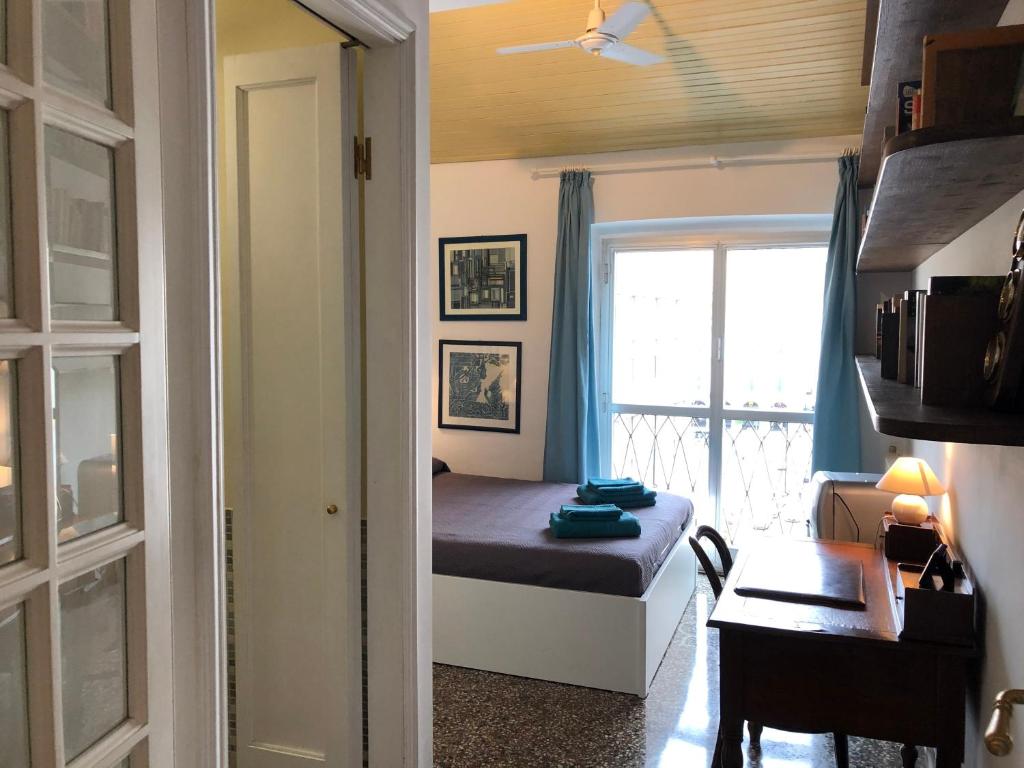 a bedroom with a bed and a desk and a window at Dormire nel cuore di Genova in Genoa