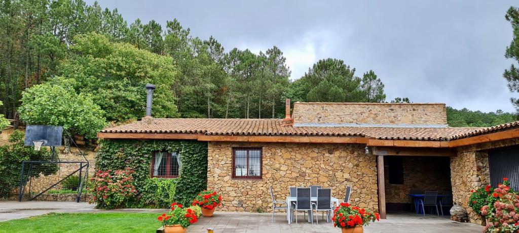 a stone house with flowers in front of it at Casa Rural Sierra de Aguafría. Finca El Robledillo in Monesterio
