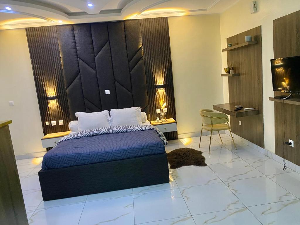 a bedroom with a bed and a table and a chair at Chambre meublée - Bonapriso in Douala