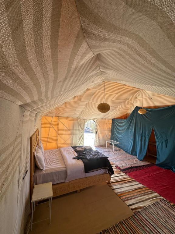 a bedroom with a bed in a tent at Le xury camp in Hassilabied