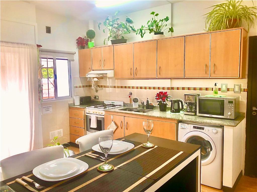 a kitchen with a table with chairs and a microwave at Alquiler por dia "Como en Casa" Caseros, cerca de Palomar y Hurlingham in Caseros