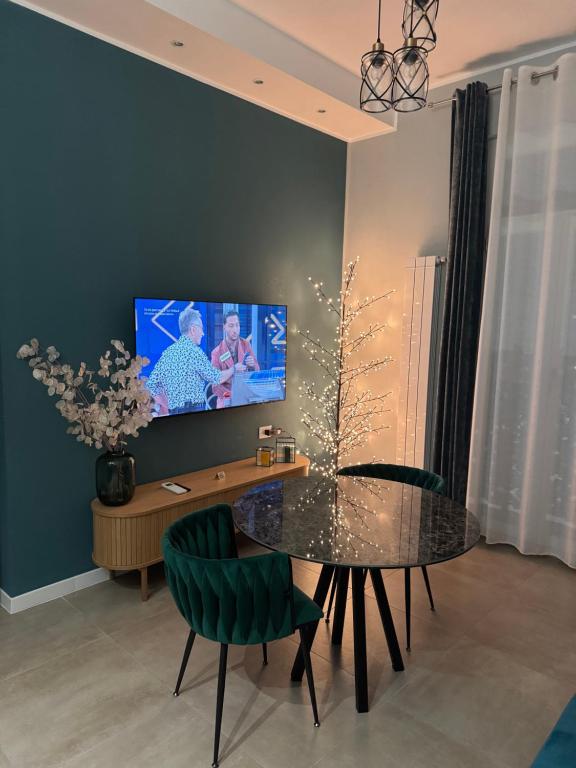 een eetkamer met een tafel en een tv aan de muur bij Alan'S Home in Terni