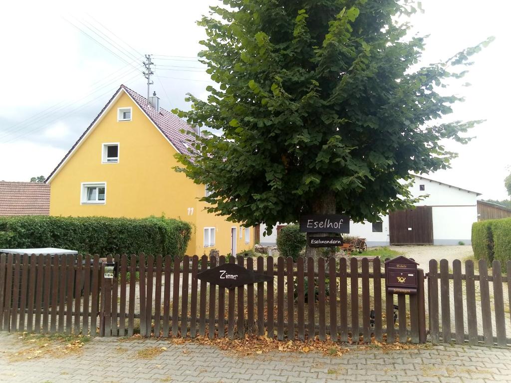 a wooden fence in front of a house with a tree at Monteurwohnung bei Crailsheim Feuchtwangen in Fichtenau