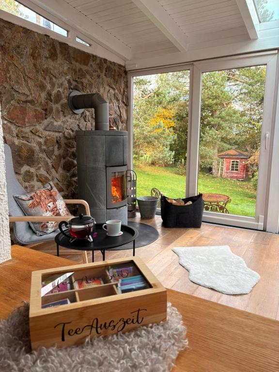 a living room with a fireplace and a stone wall at Haus Porsche in Hellenthal