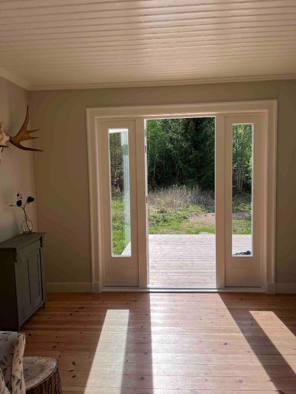 an empty room with doors open to a patio at Huisje weltevreden in Ekshärad