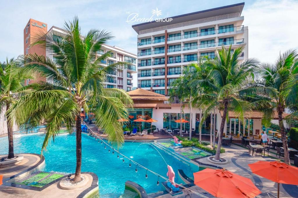 een zwembad met palmbomen en parasols bij Stay Kata in Kata Beach