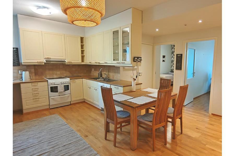 a kitchen with a table and chairs and a sink at Kotimaailma Woody 3 in Lahti