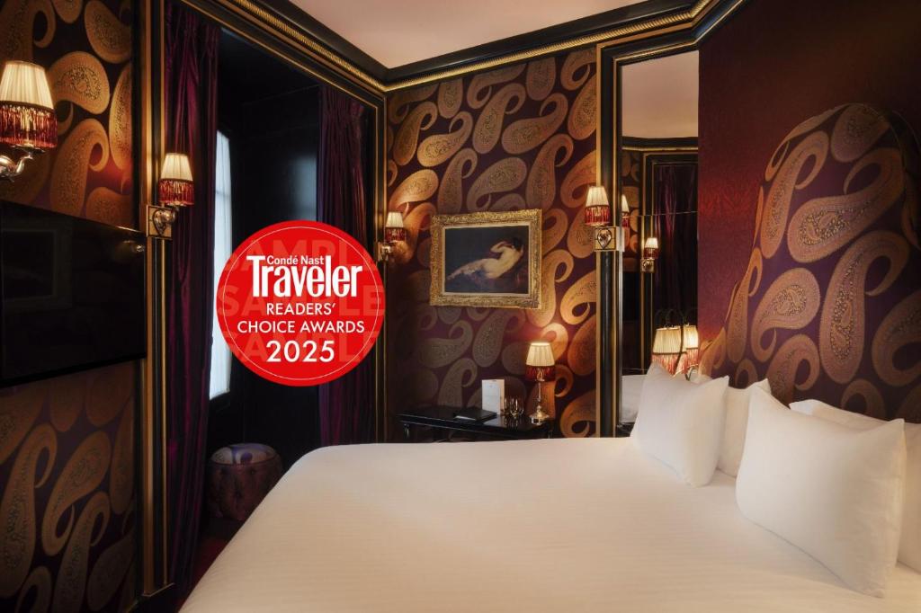 Un pat sau paturi într-o cameră la Maison Souquet, Hotel & Spa