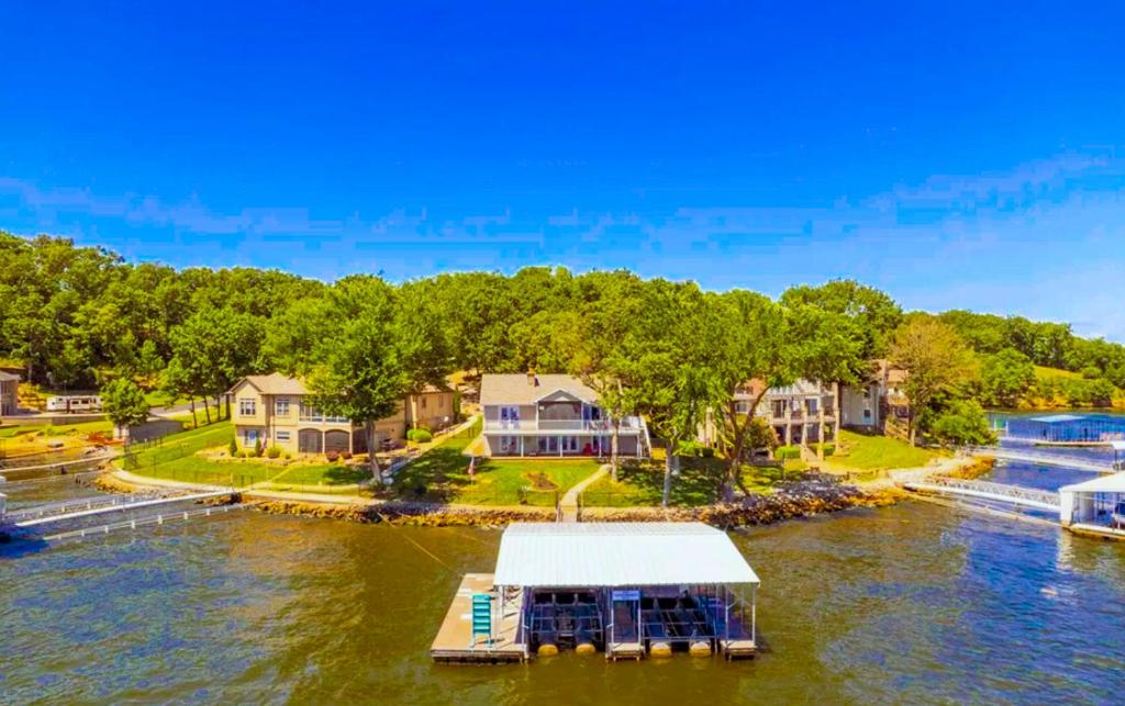 a home on a river with a dock and houses at Edgewater-Lakefront 3 BD25BADeckDockGril-16P in Sunrise Beach