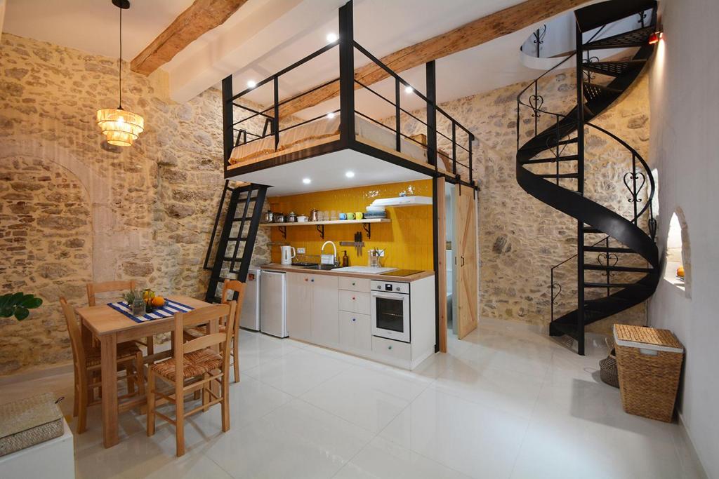 a kitchen with a wooden table and a spiral staircase at Agapi in Kissamos