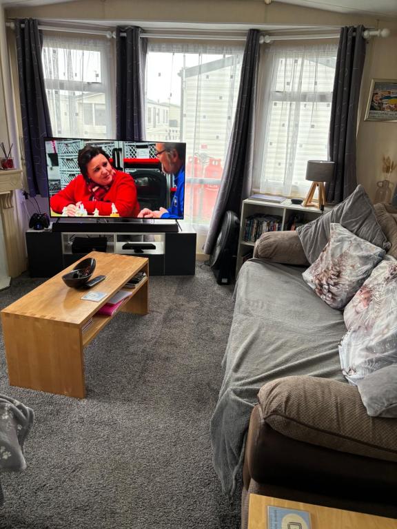 een woonkamer met een bank en een tv bij Bobbys Bolthole2 in Heysham