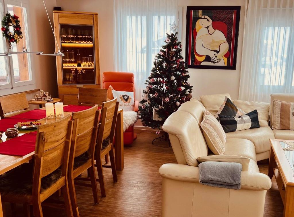 una sala de estar con un árbol de Navidad y una mesa y sillas en Engel Ingold Lodge Chalet "Bärgblümli", en Habkern