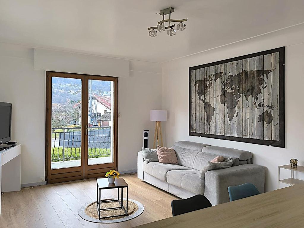 Appartement Le Bargy في Scionzier: غرفة معيشة بها أريكة وطاولة