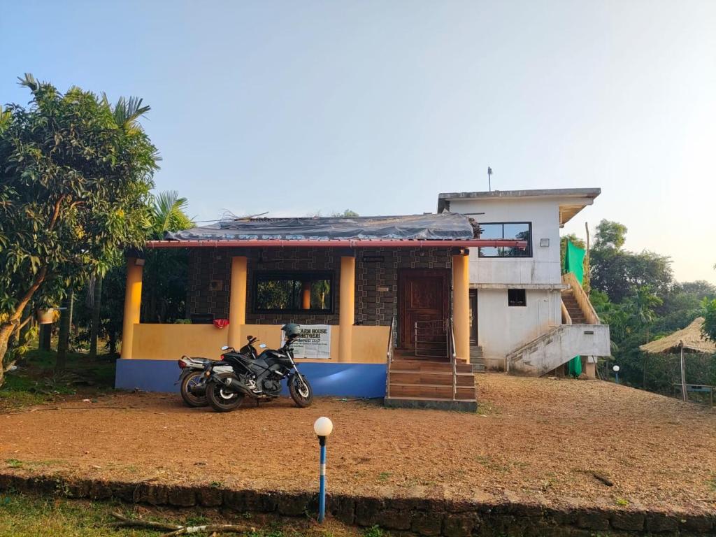 ein Motorrad, das vor einem Haus geparkt ist in der Unterkunft Farm House Shetgeri in Ankola