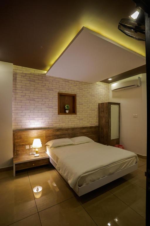 a bedroom with a large bed and a brick wall at Atholi Residency in Mukkam