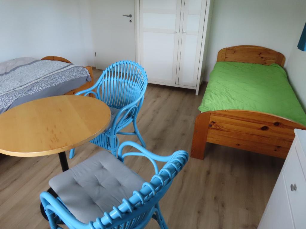 a room with two beds and a table and chairs at Monteurwohnung bei Crailsheim Feuchtwangen in Fichtenau