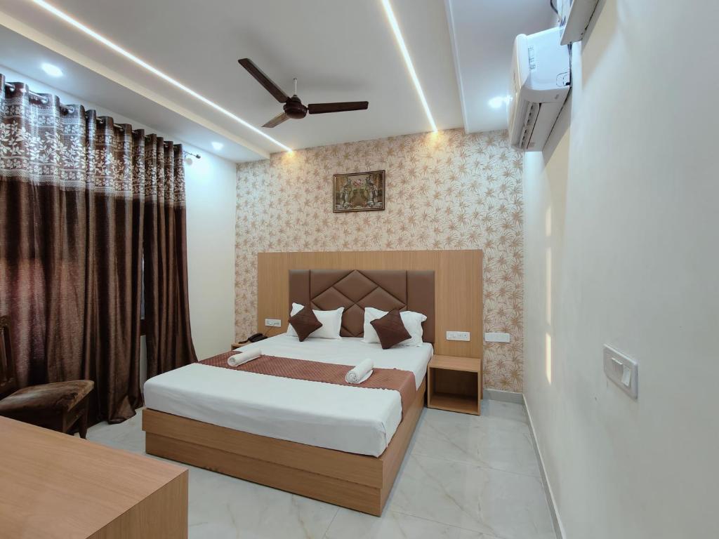 Hotel Pilgrim Near Golden Temple في أمريتسار: غرفة نوم مع سرير كبير وتلفزيون