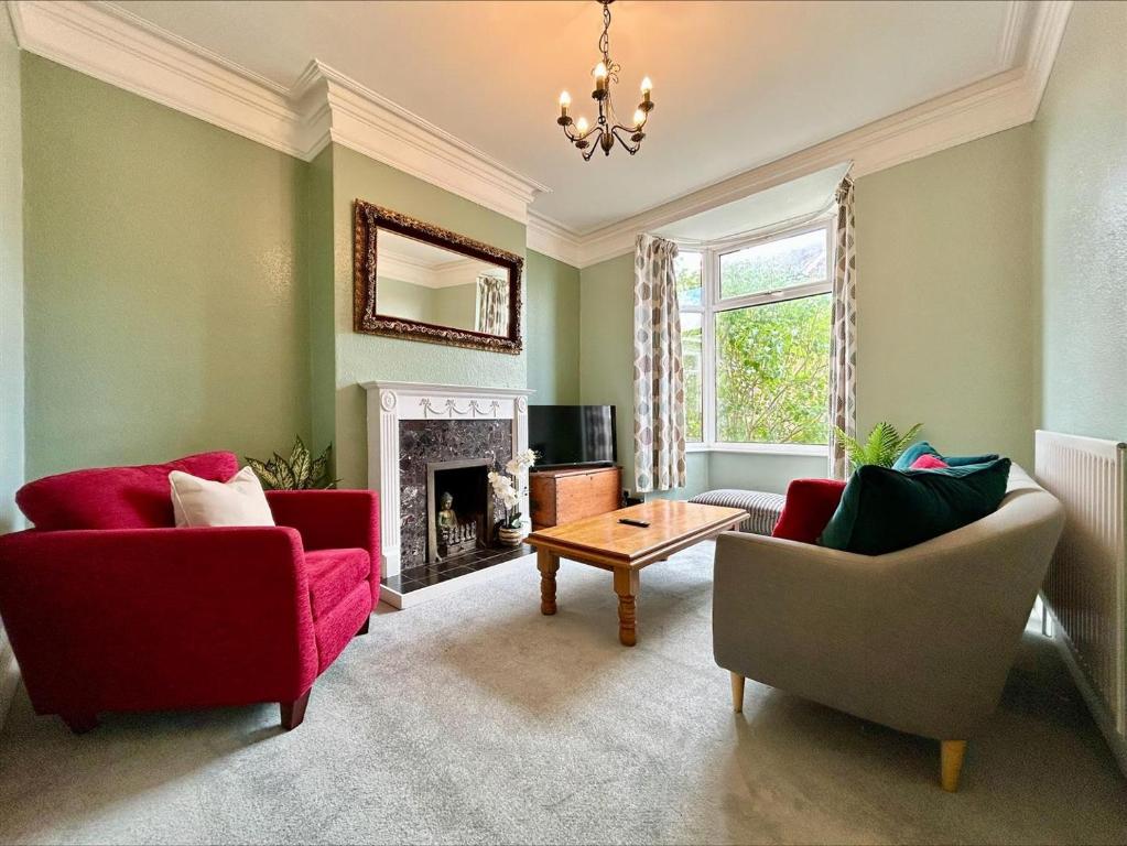 a living room with two red chairs and a fireplace at Monet's in Telford