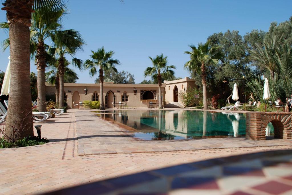 a resort with a swimming pool and palm trees at Hotel Dar Zitoune Taroudant in Taroudant