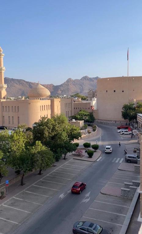 a city street with cars driving down a road at Qala View Inn in Nizwa