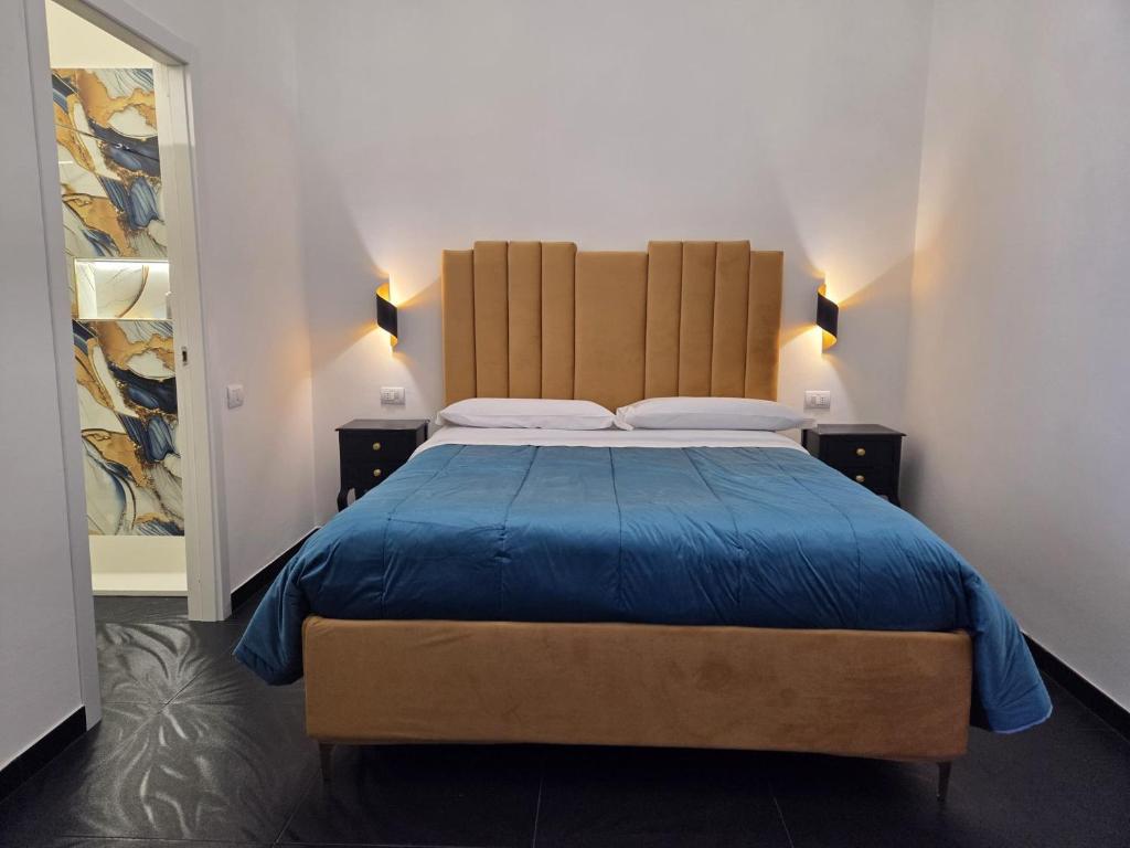 a bedroom with a large bed with a blue blanket at Sognando Vietri e SPA Esclusiva P T in Aversa