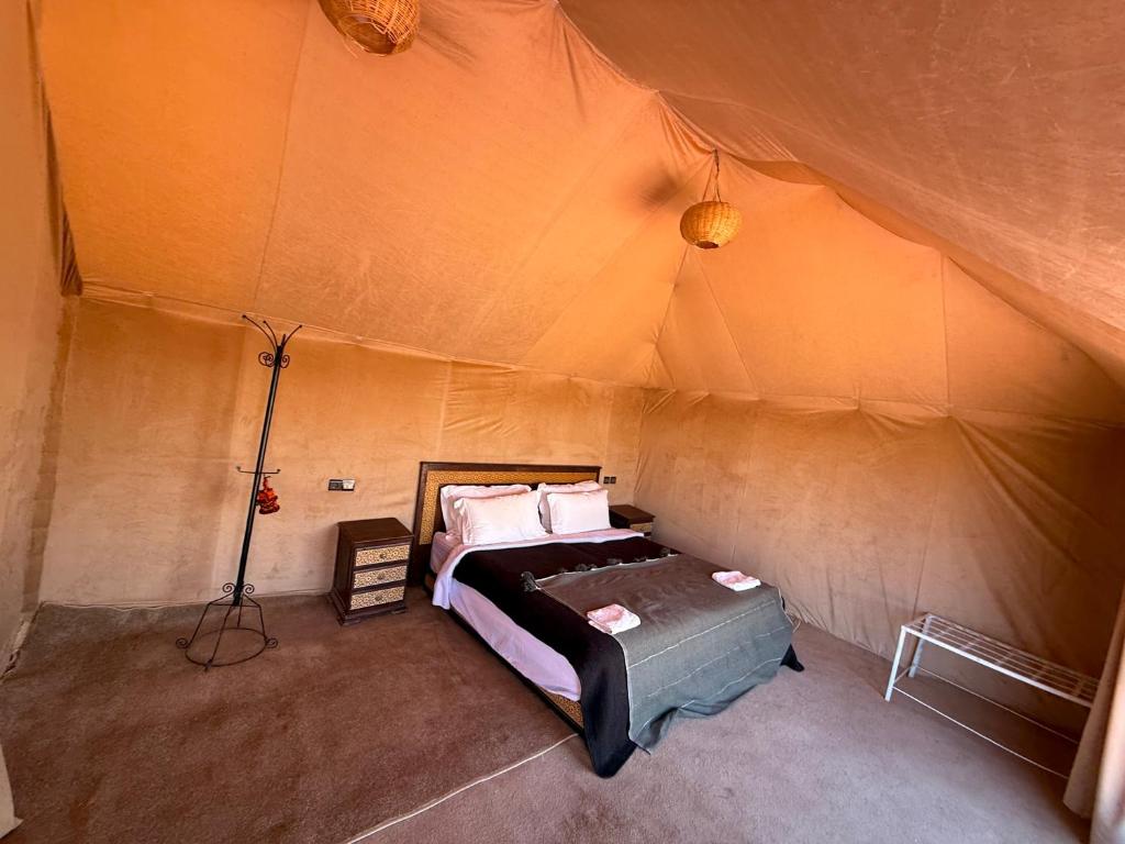 a bedroom with a bed in a tent at Camel luxury camps Merzouga in Merdani