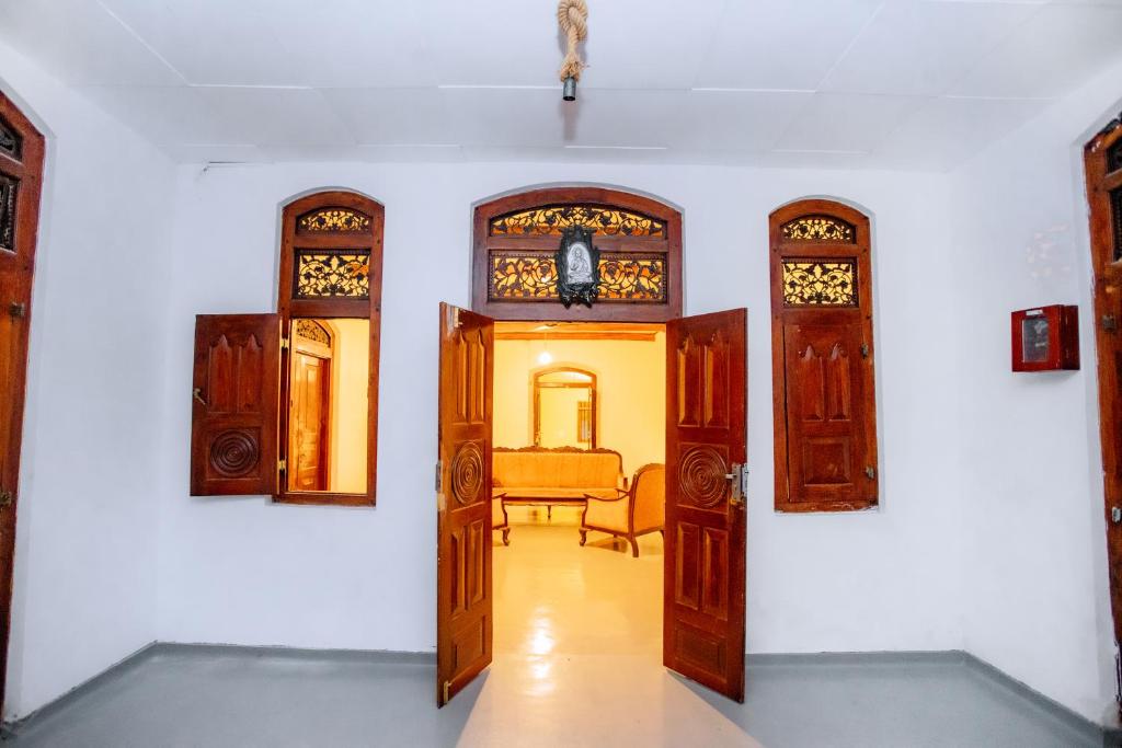 een hal met houten deuren en een woonkamer bij Ramya Villa in Weligama
