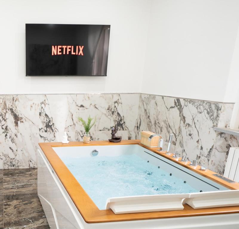a hot tub in a bathroom with a tv at Villa La Torre in San Giuliano Terme