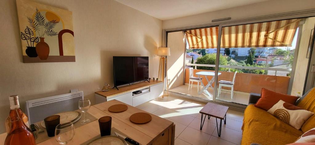una sala de estar con un sofá y una mesa en Appartement Port Santa Lucia, en Saint-Raphaël