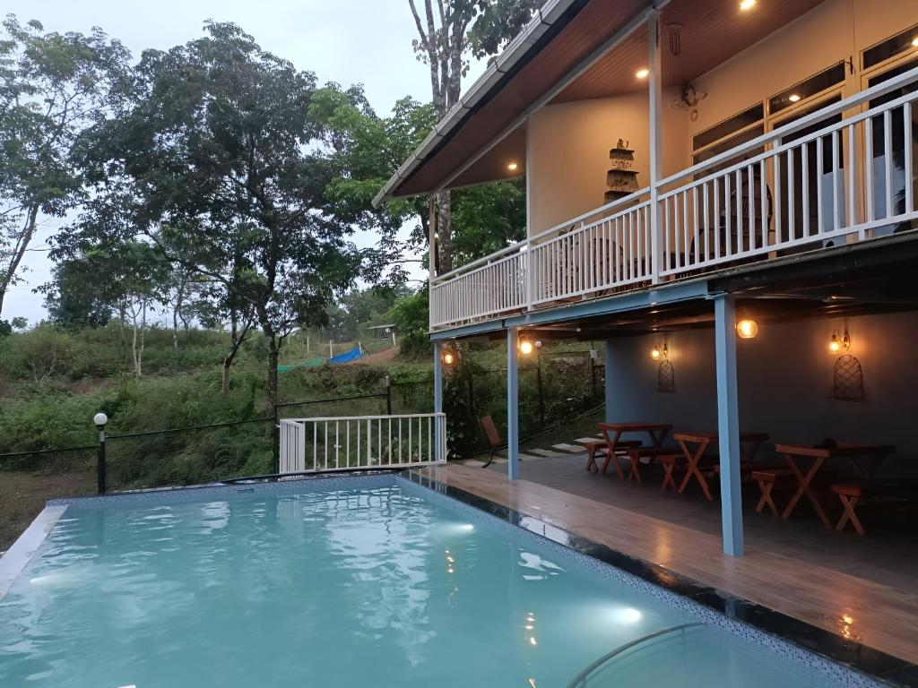 una casa con piscina delante de una casa en The Aradhya Villa, en Wayanad