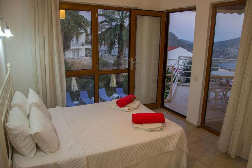 Schlafzimmer mit einem Bett mit roten Kissen und einem Balkon in der Unterkunft Villa Tara in Kaş