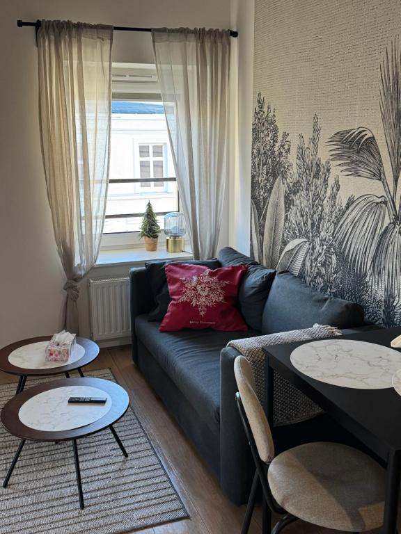 een woonkamer met een blauwe bank en twee tafels bij Apartament Centro 9 in Leszno