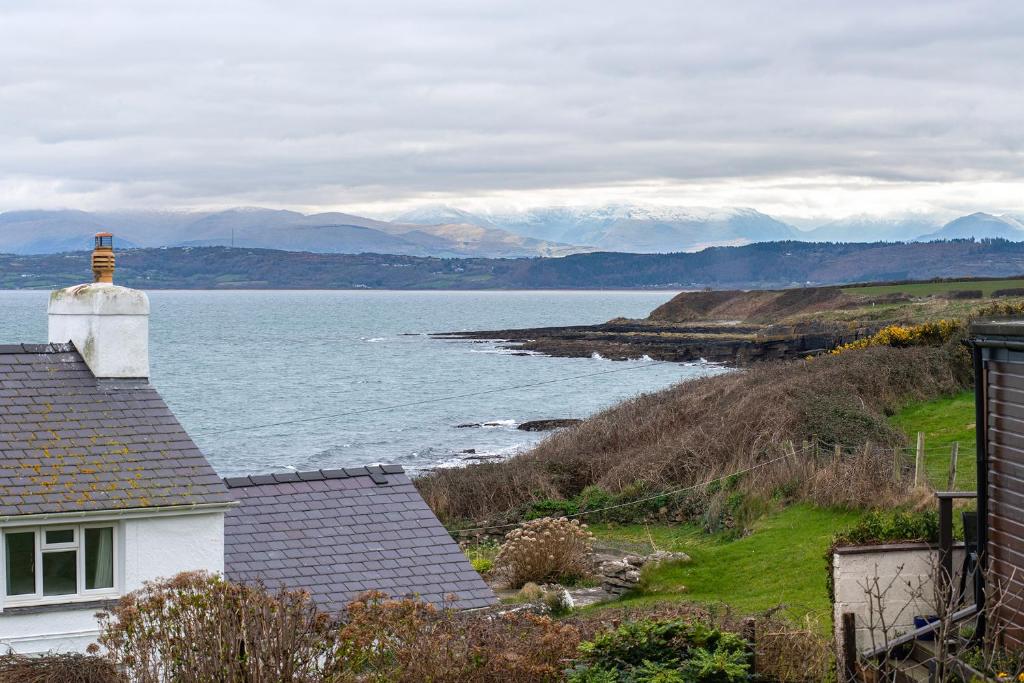 a house with a view of a body of water at Heligog at Deanfield House Moelfre Sea view adult only appartment in Moelfre in Moelfre