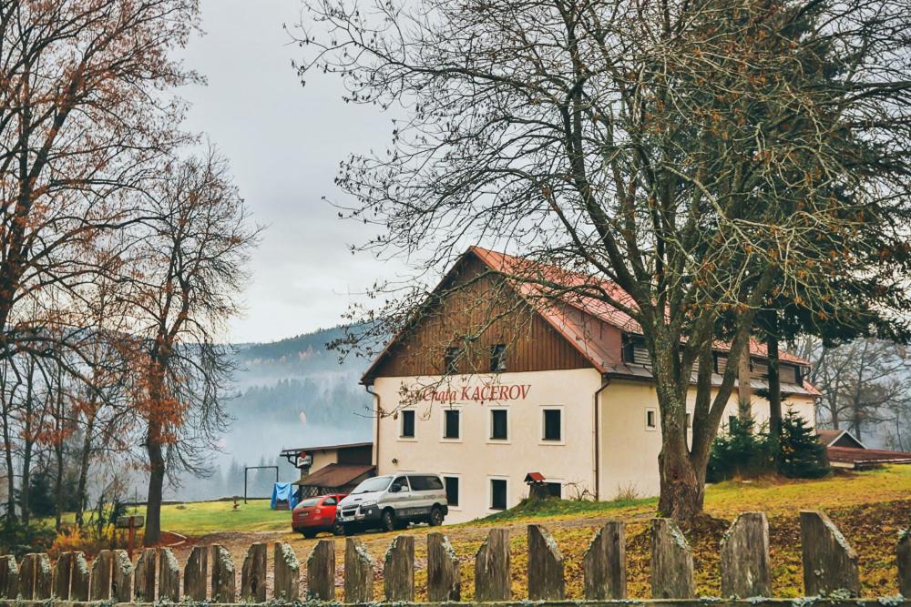 a truck parked in front of a white building at Chata Kačerov in Kašperské Hory
