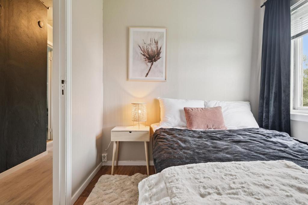 House in the middle of Lofoten - Leknes في ليكنيز: غرفة نوم بها سرير وطاولة ومصباح