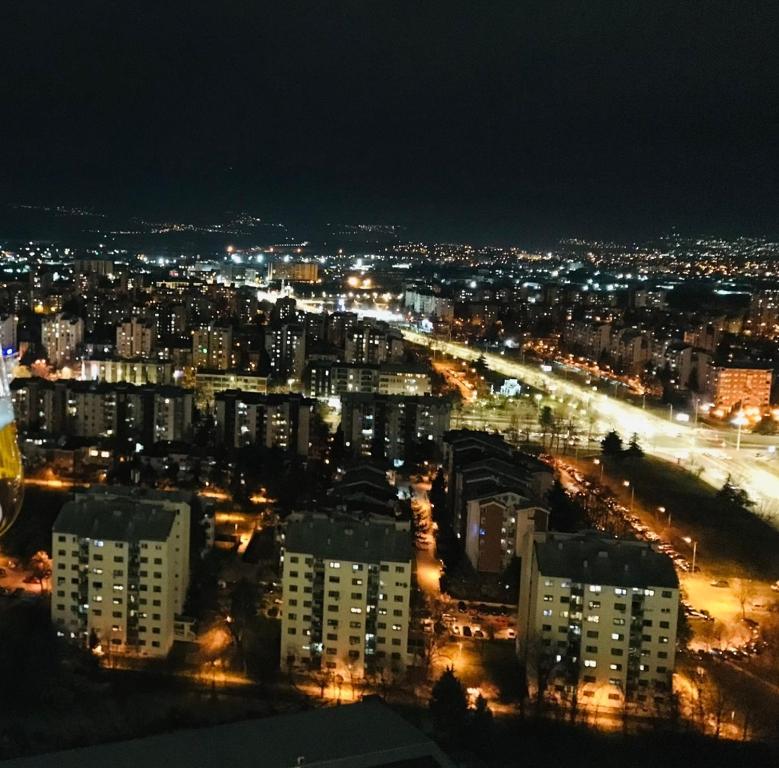 28th Floor Sky City View Apartment في إسكوبية: منظر للمدينة في الليل مع الأضواء