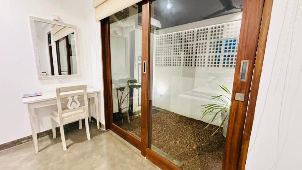 a room with a mirror and a table and a chair at Vintage 83 Tangalle in Tangalle