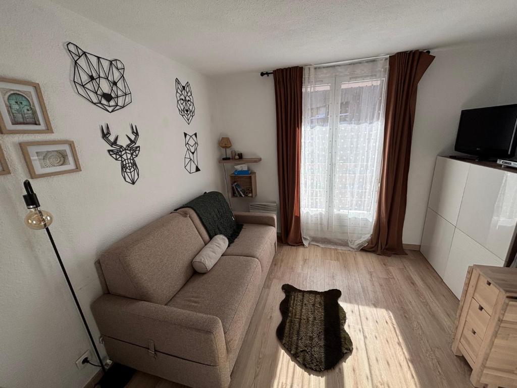 Una sala de estar con un sofá y una ventana. en Studio Risoul 1850, en Risoul