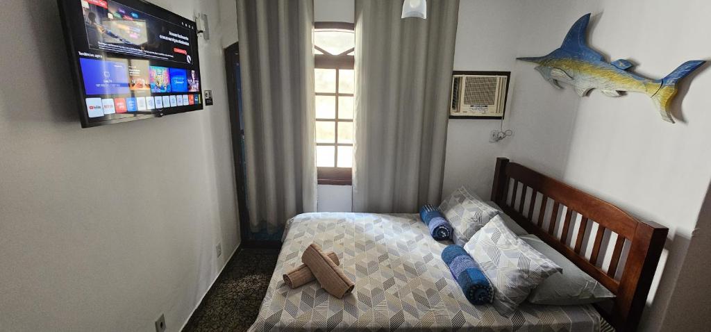 a bedroom with a bed with a fish on the wall at Suíte Trilha do Sol 2 in Arraial do Cabo