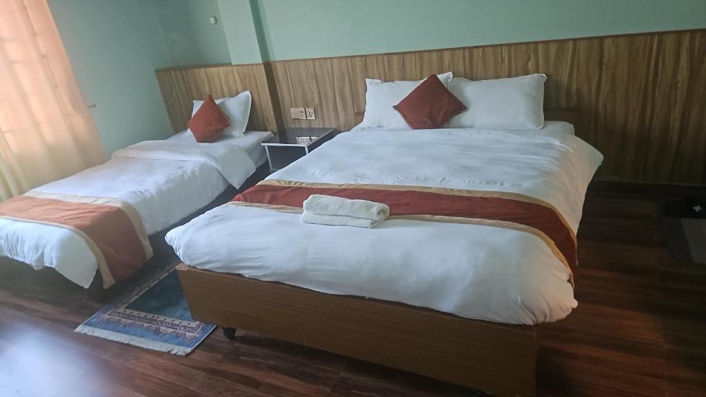 deux lits dans une chambre d'hôtel avec des serviettes dessus dans l'établissement Cozy house, à Sauraha